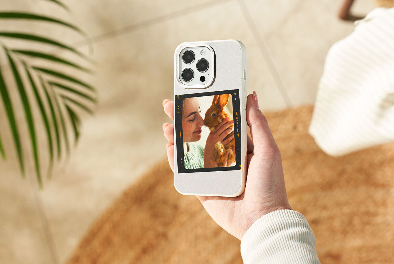 Een hand houdt een smartphone vast met een konijnenfoto op het scherm.