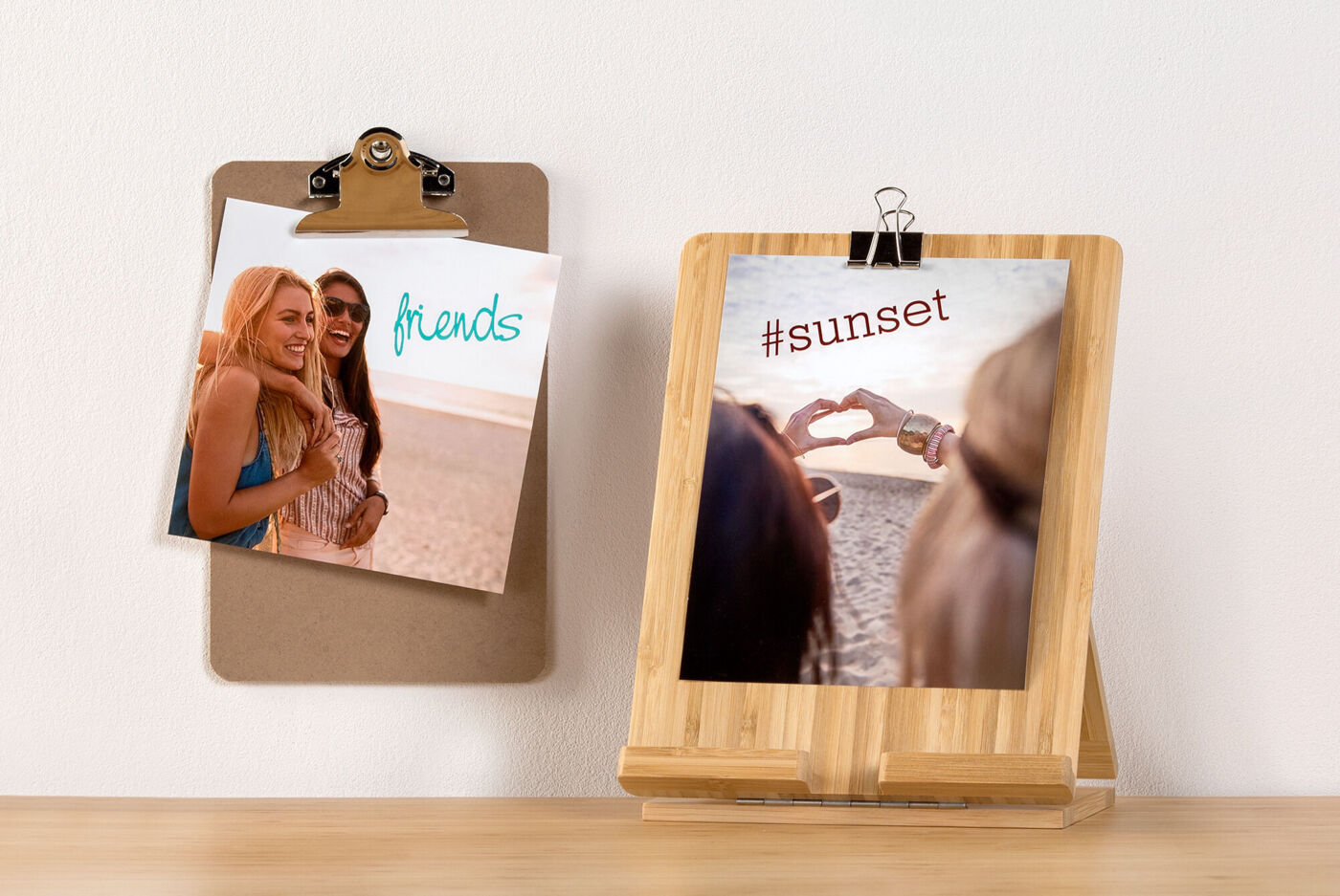 Twee foto's hangen aan de muur, één toont vriendschap, het andere een hartelijk gebaar bij zonsondergang.